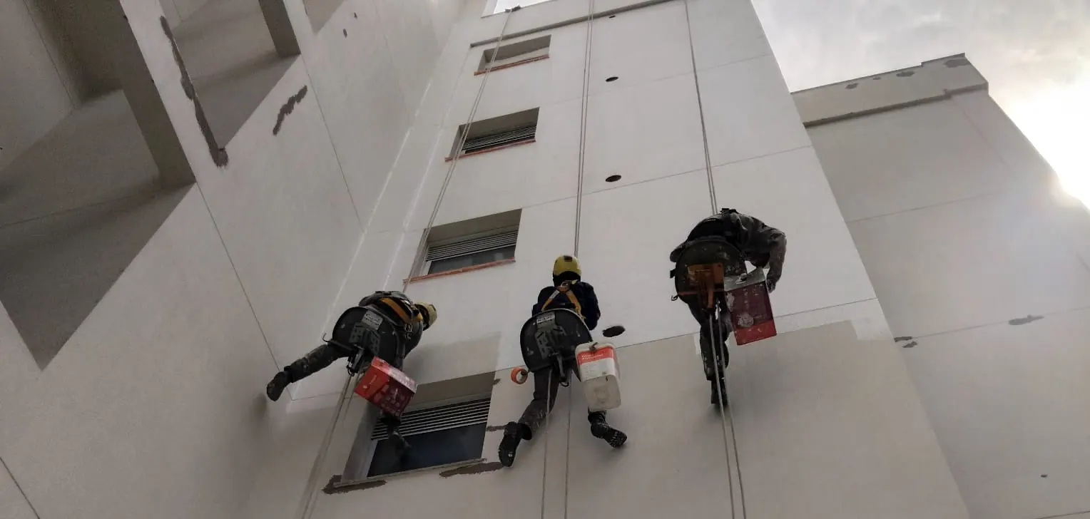 Três profissionais da Strucon em acesso por corda na fachada do Boulevard Coqueiros